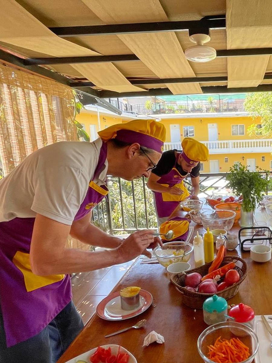 Travelers preparing lomo saltado during a hands-on cooking class in Arequipa